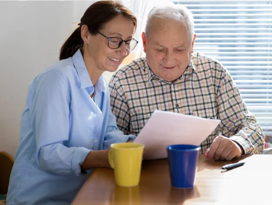 Woman and older man reading documents together at a table